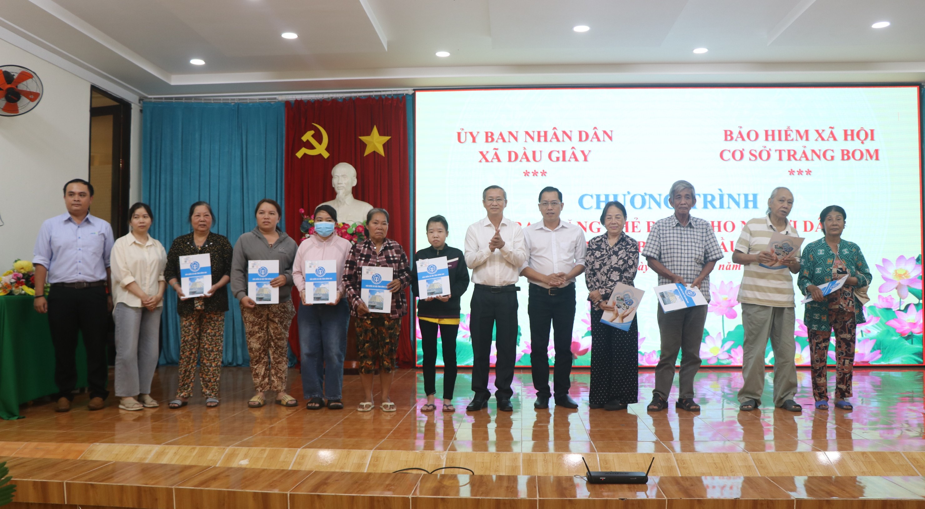 Bí thư Đảng ủy Cao Tiến Sỹ cùng các đơn vị tài trợ trao thẻ BHYT cho người dân tại chương trình