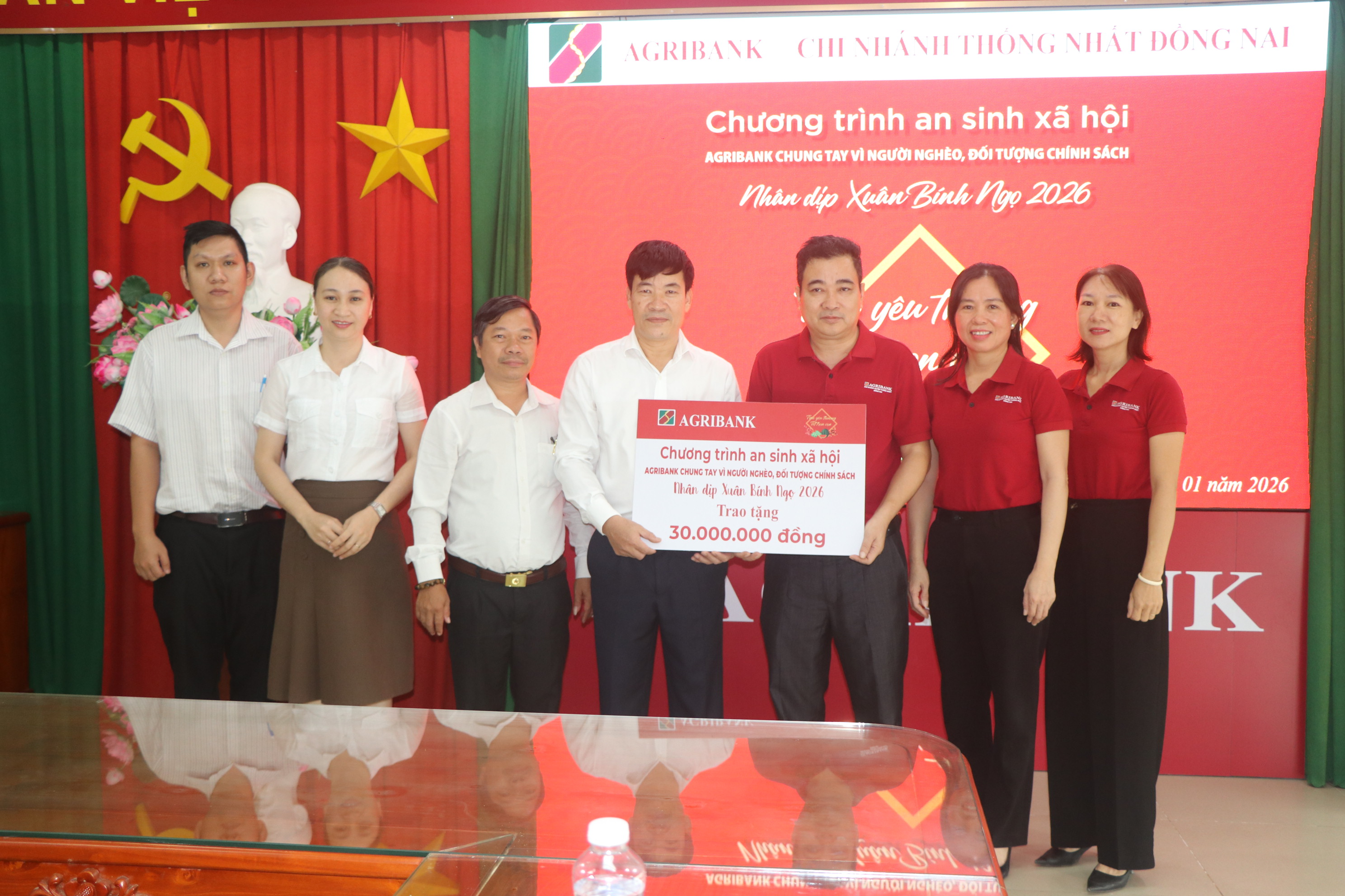 Ban Giám đốc Agribank Chi nhánh Thống Nhất Đồng Nai trao bảng tượng trưng số tiền 30 triệu đồng cho lãnh đạo xã Dầu Giây