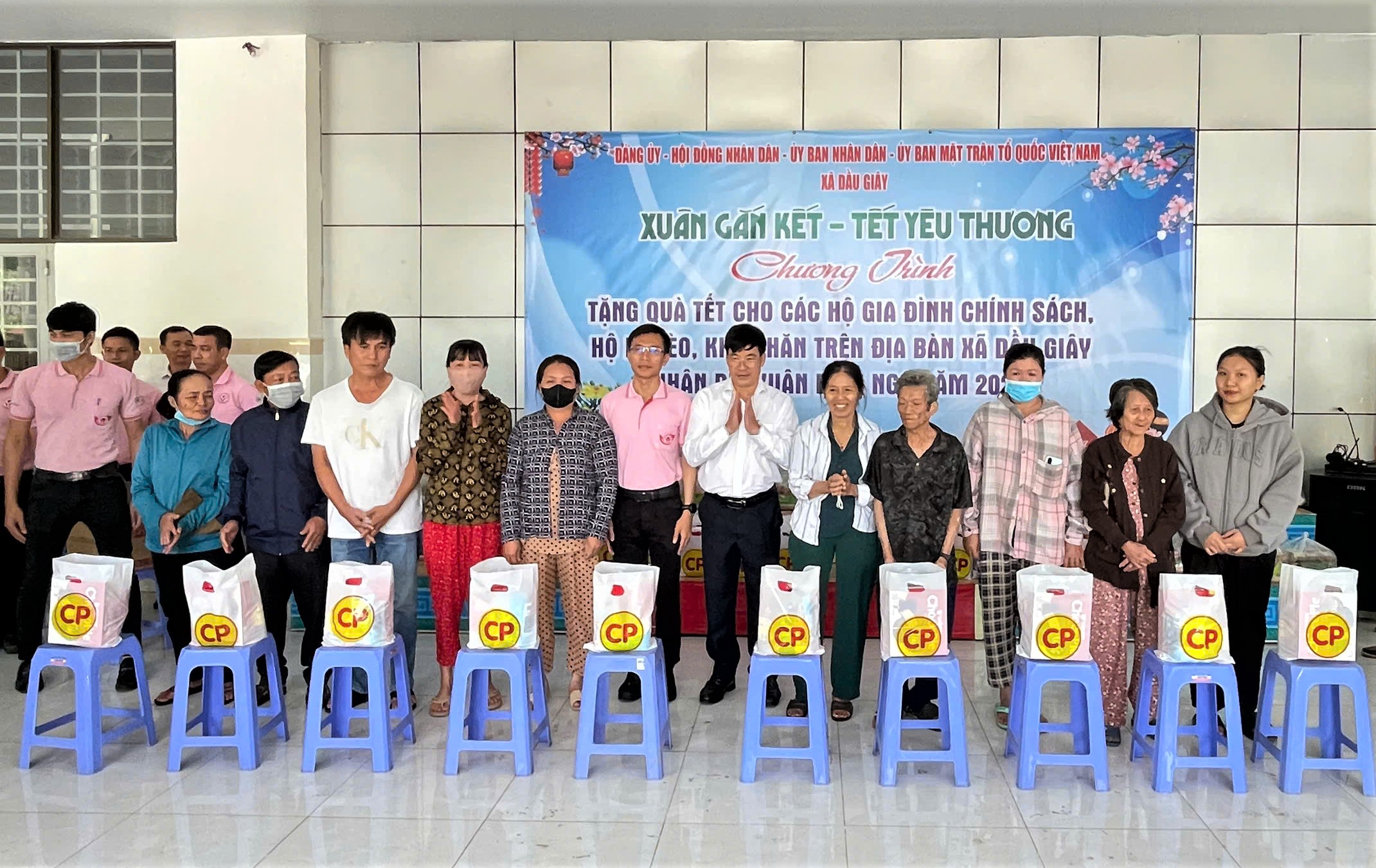 Đại diện Công ty Cổ phần Chăn nuôi CP Việt Nam và lãnh đạo xã Dầu Giây trao quà cho các nạn nhân