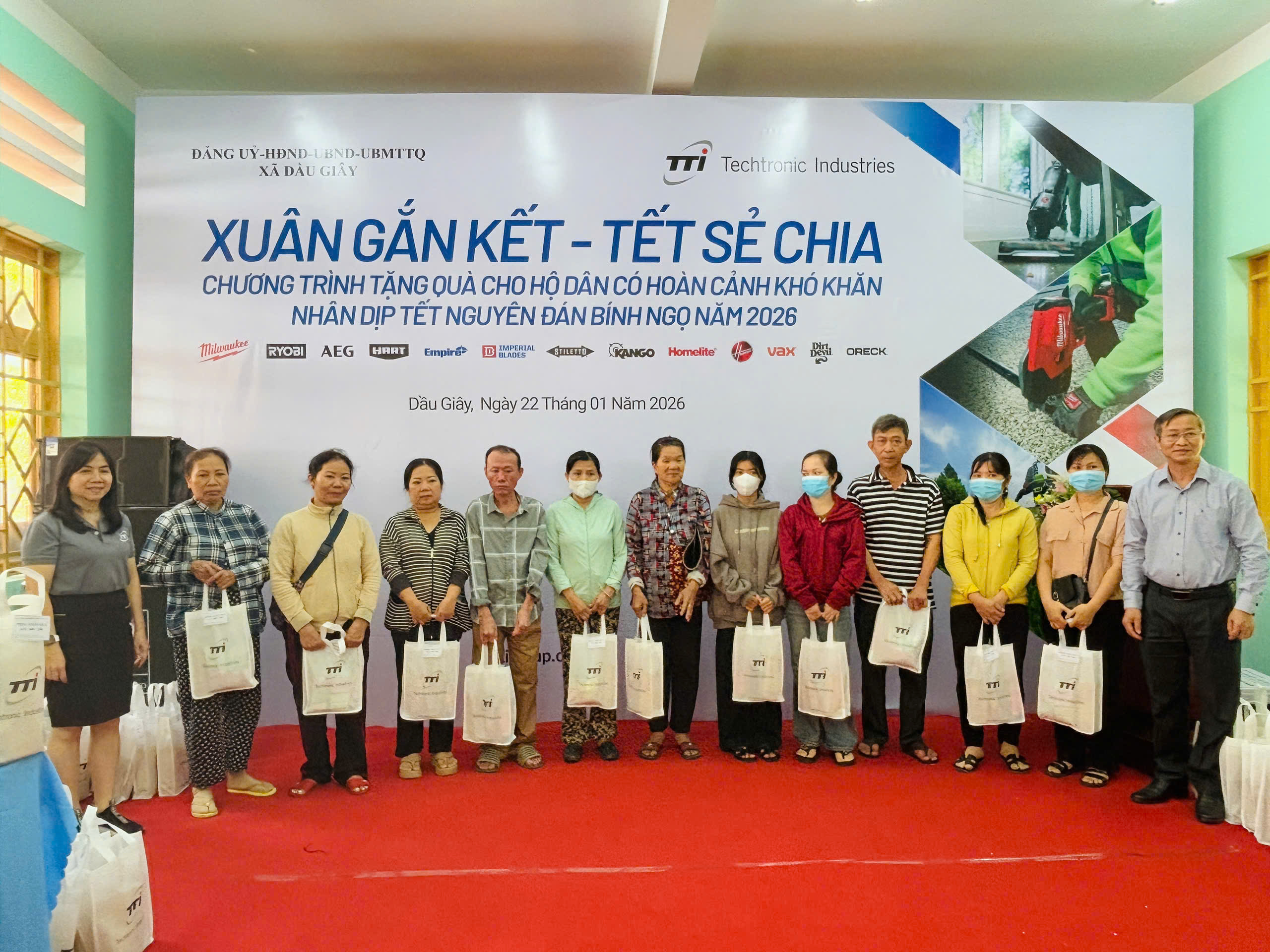 TUV, Bí thư Đảng ủy, chủ tịch HĐND xã Dầu Giây Cao Tiến Sỹ (bên phải ngoài cùng) và đại diện đơn vị tài trợ trao quà cho các hộ nghèo, hộ khó khăn tại chương trình